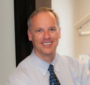 Portrait of Dr. Eric A. Dale smiling in a dental treatment room